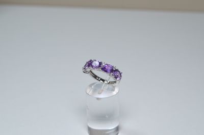 a ring with a purple stone on top of a clear glass