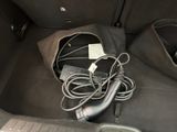 a cord in the trunk of a car that is plugged into a charger