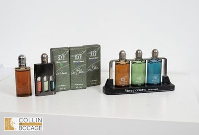trois flacons d'eau de Cologne posés sur une table, à côté d'une boîte contenant des eaux de Cologne