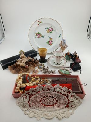 a table with a plate, a tray with beads, a tray with beads, and a plate with a cup and saucer on it