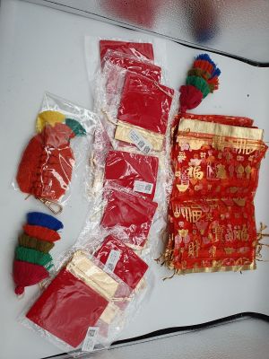 many bags of red and gold decorations on the table