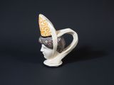 porcelain figurine of a woman with a hat on her head