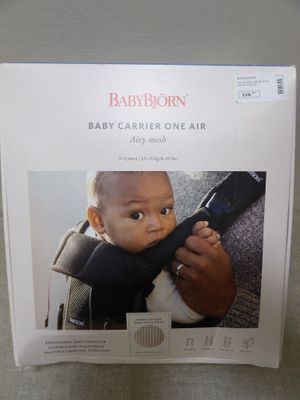 le porte-bébé est tenu par un homme assis sur un siège auto