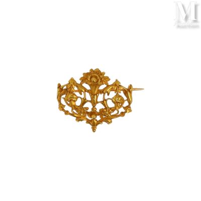 un gros plan d'une broche en or sur fond blanc