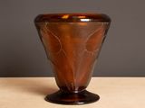 a brown glass vase sitting on a wooden table