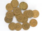 some gold coins are scattered on a white surface with a white background