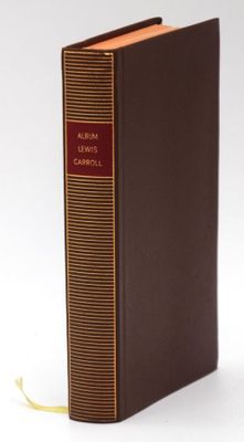 a brown book with a red cover sitting on top of a white surface
