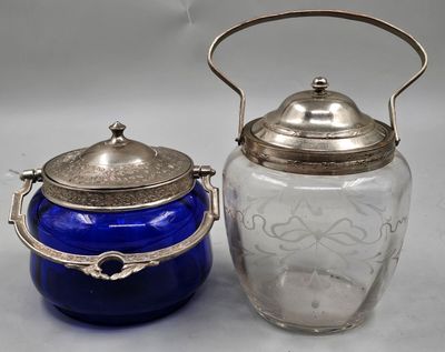 two blue glass jars with silver lids on a table