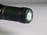 a bottle of wine that has a green cap on it