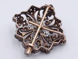 a close up of a brooch with a cross on it