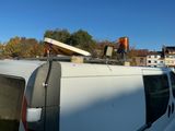 une camionnette avec une planche de surf sur le toit, garée sur un parking