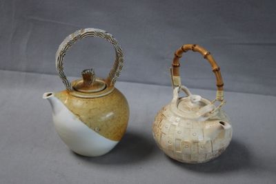 two teapots that are next to each other on a table