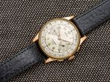 un gros plan d'une montre avec un bracelet noir posée sur une surface noire