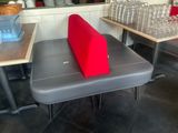 un coussin rouge posé sur un banc gris dans un restaurant