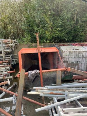 un tas de tuyaux métalliques à côté d'un tas de bois