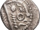 une pièce d'argent sur laquelle figurent un visage et des mains