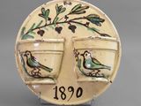 a ceramic plate with a bird on it and two cups on it