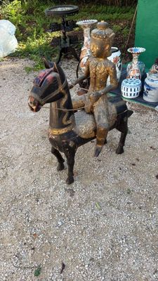 une statue représentant un homme à cheval, à côté d'autres statues
