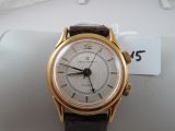 a gold wrist watch with a white dial on it