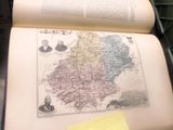 un livre ouvert posé sur une table, sur laquelle se trouve un autocollant jaune
