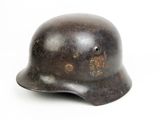 an old helmet is sitting on a white surface with a white background
