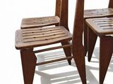 two wooden chairs sitting next to each other on a white surface