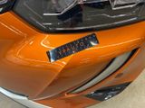 a close up of a car ' s headlight with a sticker on it