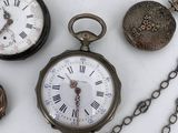 many different types of pocket watches on the table