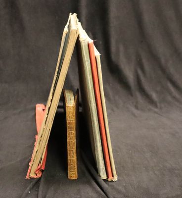 Plusieurs livres sont empilés les uns sur les autres sur un fond noir