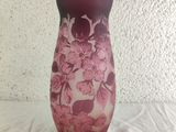 a purple vase with pink flowers on it sitting on a table