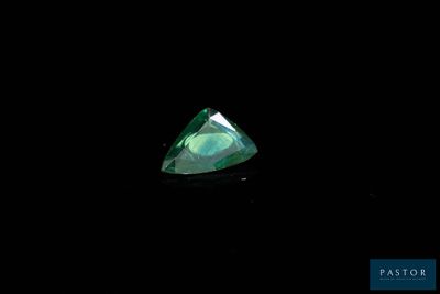 a close up of a green diamond on a black background