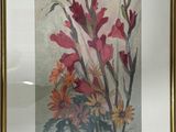 painting of a bouquet of flowers in a gold frame on a white wall
