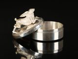 two wedding rings with a horse on top of them on a black surface