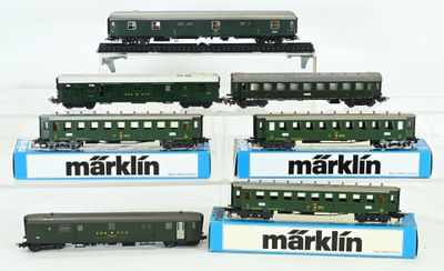six trains miniatures exposés sur une surface blanche