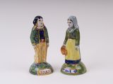 pair of ceramic figurines of a woman and a man with a basket