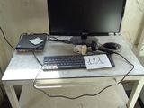 a computer desk with a keyboard and a monitor on it
