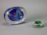 un objet en verre posé à côté d'un petit objet en verre