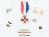 an image of a medal, pins, and a ruler on a white surface