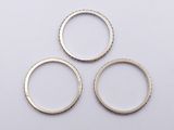three silver rings on a white surface with a white background