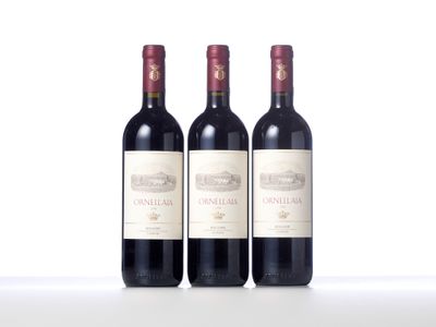 trois bouteilles de vin rouge posées sur une table blanche