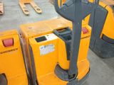 two yellow forklifts in a warehouse with pallets in the background