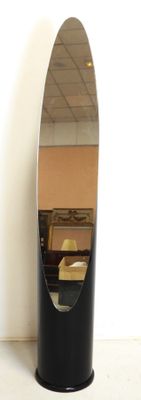 a mirror on a stand with a chair in the background
