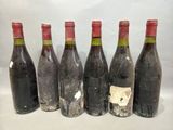six bouteilles de vin sont alignées sur une table