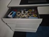 a drawer full of tape, scissors, tape, and other office supplies