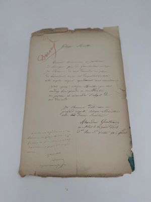 un vieux morceau de papier avec une écriture dessus, posé sur une table