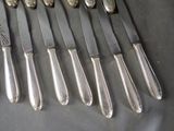 a lot of silverware on a table with a spoon and knife