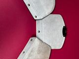 three pieces of metal on a red surface with a red background