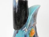 a blue and black vase with an orange base