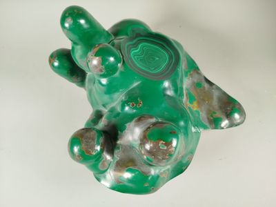 a green turtle figurine sitting on a white surface