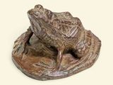 une statue représentant une grenouille assise sur une feuille